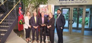 A group gathers for a photo to celebrate the expansion of the semiconductor manufacturing facility of Ranovus in Ottawa, Ontario.