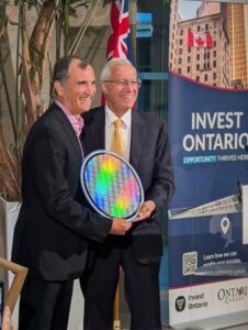 Representatives pose for a photo holding a wafer design superconductor, in celebration of an investment into the expansion of a superconductor manufacturing facility in Ontario. 
